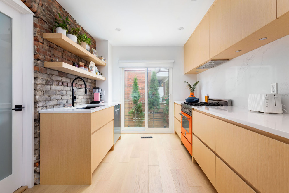 This is an example of a mid-sized modern galley kitchen in Toronto with an undermount sink, flat-panel cabinets, beige cabinets, quartz benchtops, white splashback, engineered quartz splashback, stainless steel appliances, light hardwood floors, no island, beige floor, white benchtop and wallpaper.