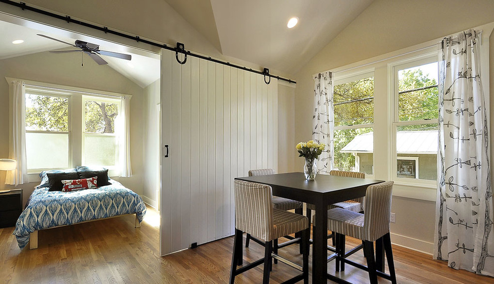 Photo of a traditional guest bedroom in Austin with white walls and medium hardwood floors.