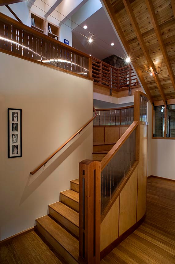 Large mountain style wooden curved mixed material railing staircase photo with wooden risers