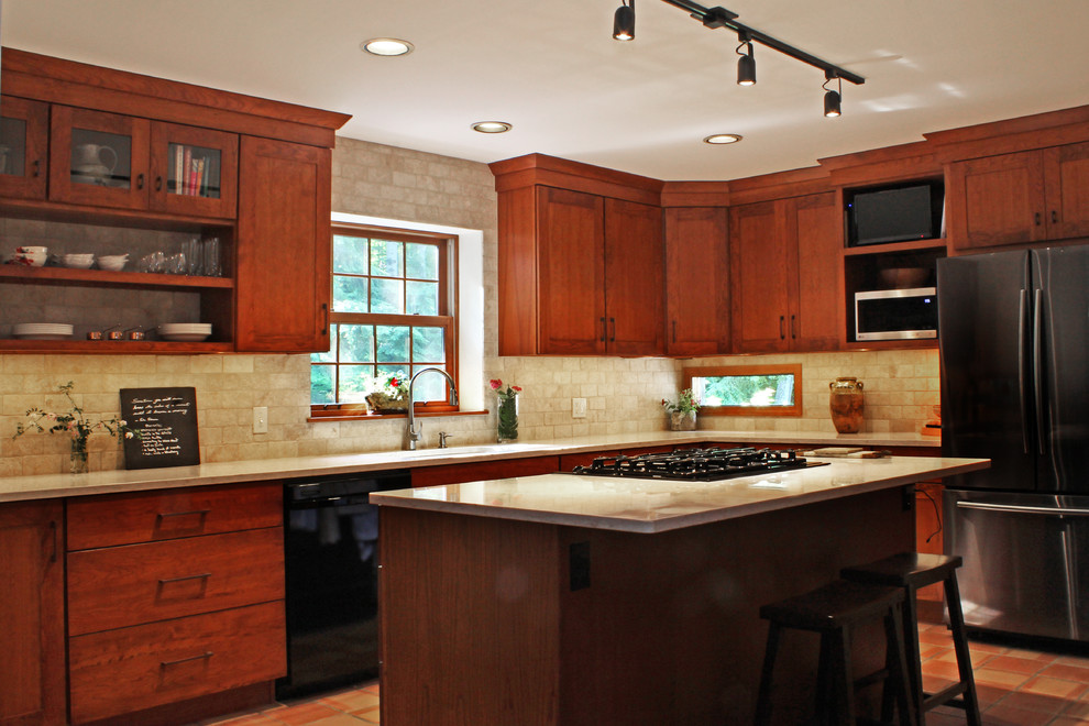 Transitional l-shaped terra-cotta tile and red floor eat-in kitchen photo with an undermount sink, shaker cabinets, medium tone wood cabinets, quartz countertops, beige backsplash, travertine backsplash, stainless steel appliances, an island and beige countertops