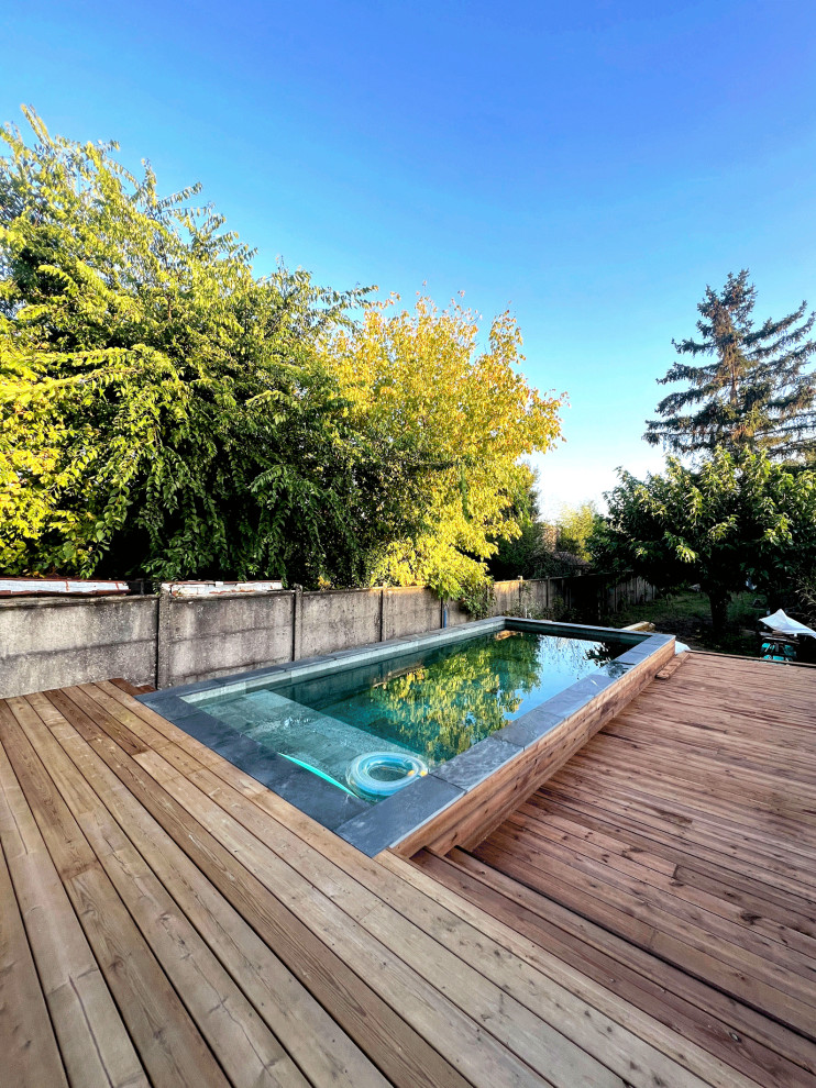 Aménagement d'une piscine bord de mer rectangle avec une terrasse en bois.