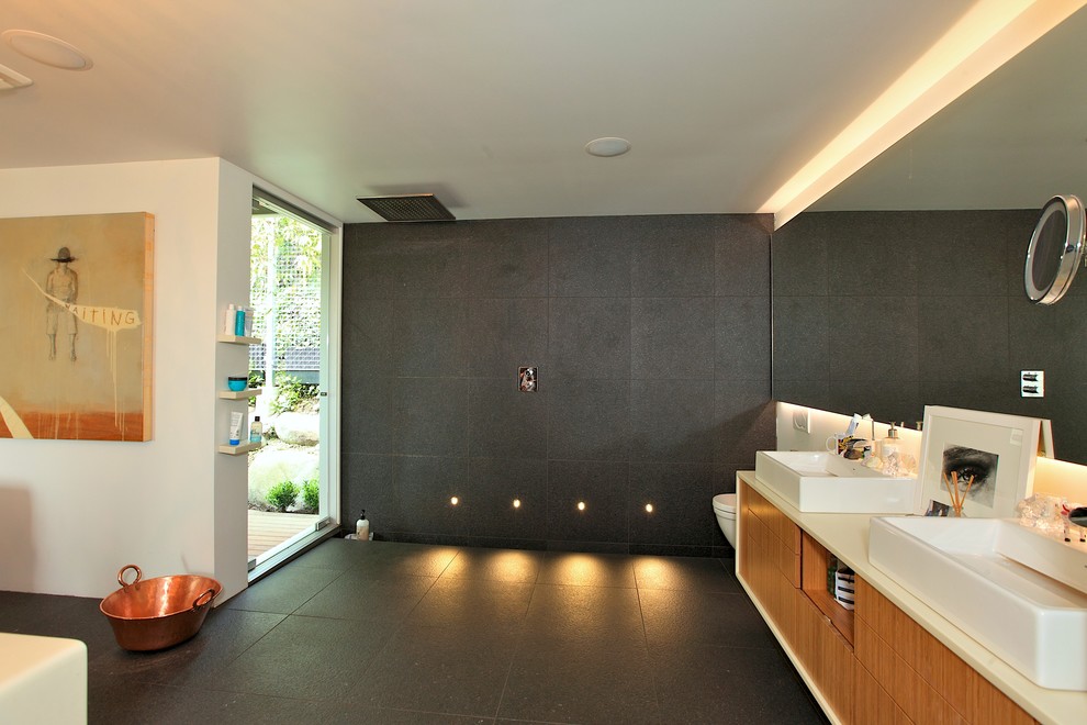 Inspiration for a large modern master bathroom in Vancouver with an integrated sink, flat-panel cabinets, light wood cabinets, engineered quartz benchtops, an open shower, a wall-mount toilet, gray tile, ceramic tile, white walls and slate floors.