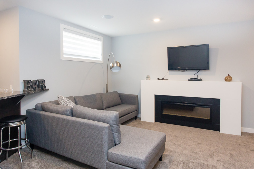 Photo of a mid-sized modern look-out basement in Calgary with grey walls, carpet and a ribbon fireplace.