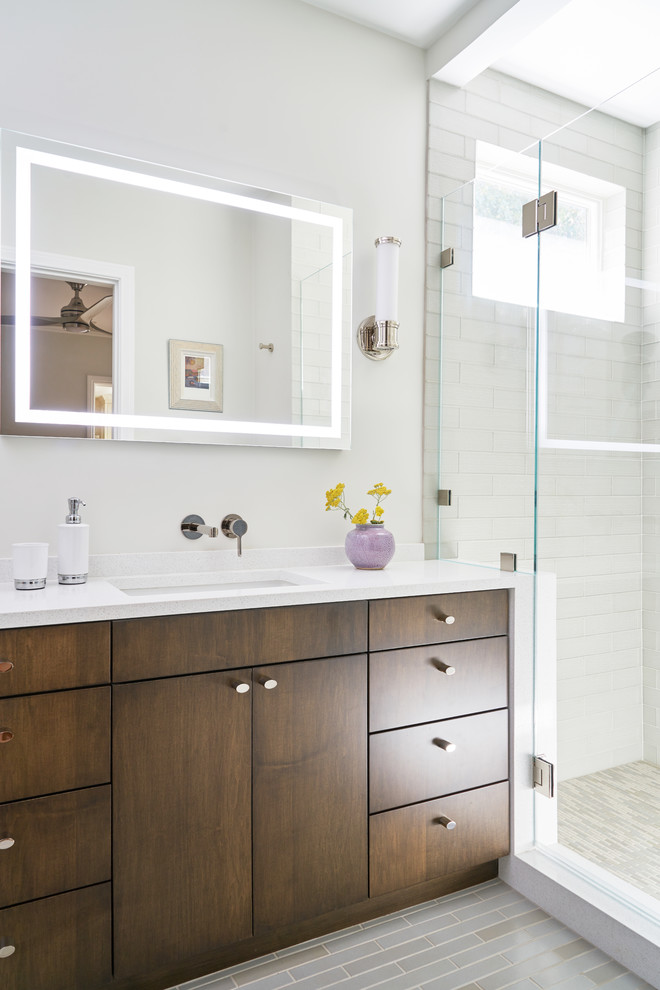This is an example of a mid-sized contemporary master bathroom in Los Angeles with flat-panel cabinets, dark wood cabinets, an alcove shower, glass tile, ceramic floors, an undermount sink, a hinged shower door, white benchtops, white tile, white walls and grey floor.