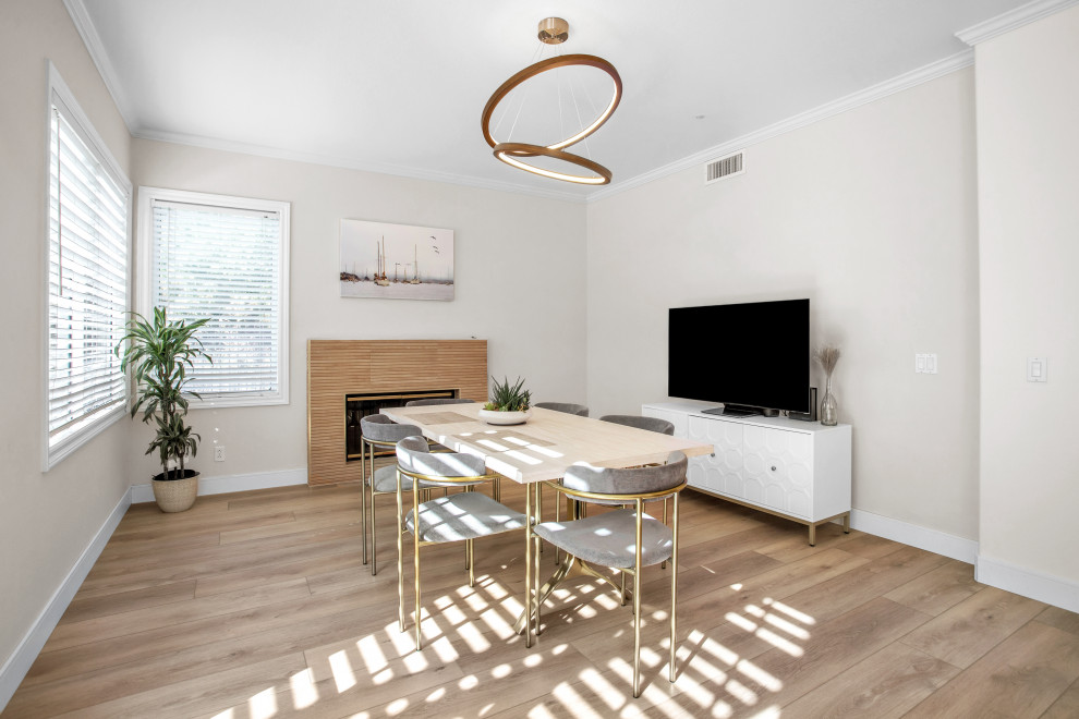 Modern inredning av en mellanstor matplats med öppen planlösning, med vita väggar, vinylgolv, en öppen vedspis, beiget golv och en spiselkrans i trä