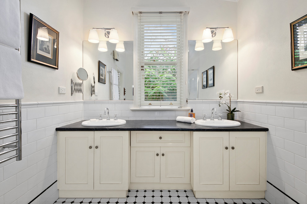 Inspiration for a large master bathroom in Sydney with beaded inset cabinets, beige cabinets, white tile, subway tile, beige walls, porcelain floors, a drop-in sink, white floor and black benchtops.