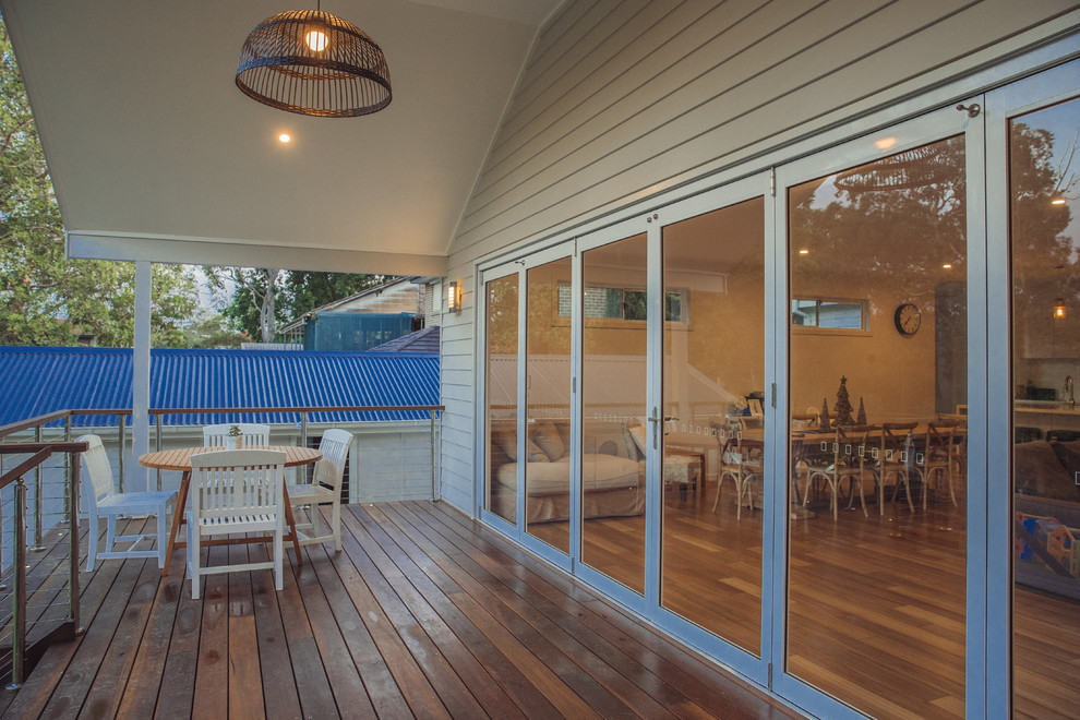 Design ideas for a large beach style backyard patio in Sydney with a roof extension.