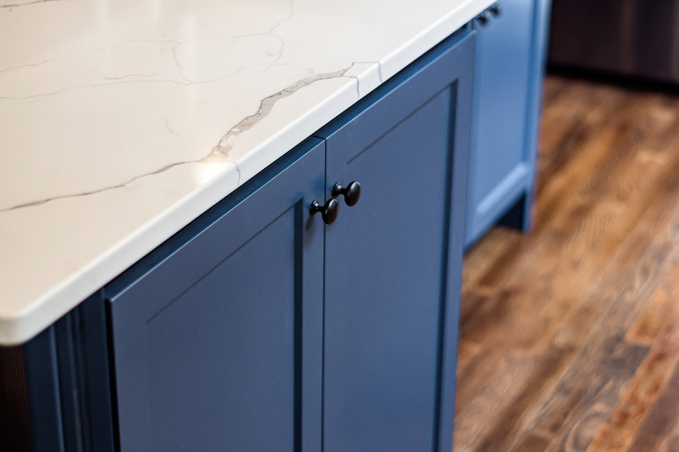 Inspiration for a large transitional u-shaped eat-in kitchen remodel in Columbus with shaker cabinets, quartz countertops, white backsplash and an island
