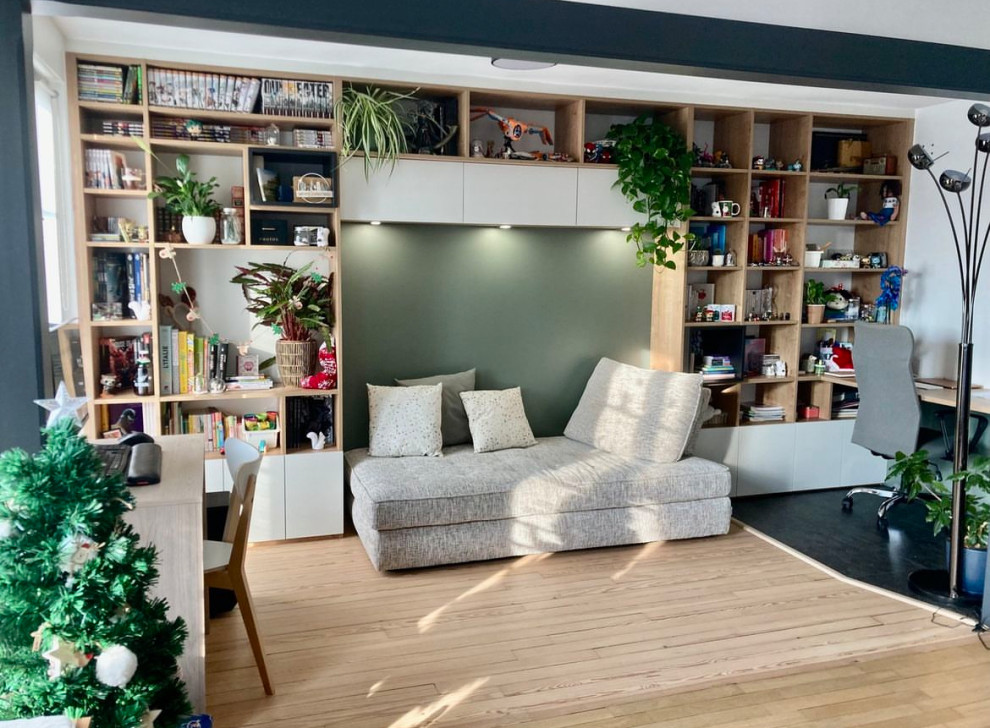 Großes Skandinavisches Lesezimmer ohne Kamin mit grüner Wandfarbe, hellem Holzboden, Einbau-Schreibtisch und freigelegten Dachbalken in Le Havre