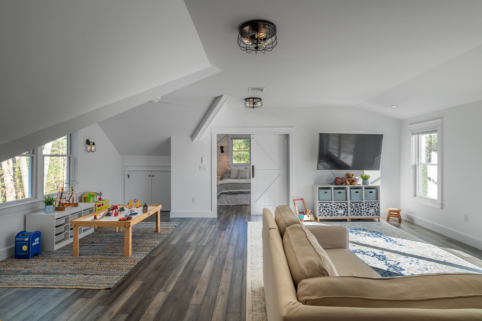 This is an example of a beach style kids' playroom in Portland Maine with white walls, dark hardwood floors and brown floor.