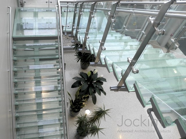 This is an example of a glass u-shaped staircase in Orange County with glass risers.