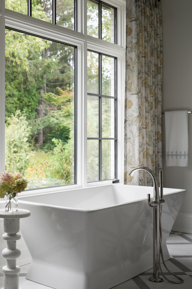 Bild på ett lantligt grå grått en-suite badrum, med luckor med infälld panel, vita skåp, ett fristående badkar, en hörndusch, vit kakel, marmorgolv, bänkskiva i kvartsit, vitt golv och dusch med gångjärnsdörr