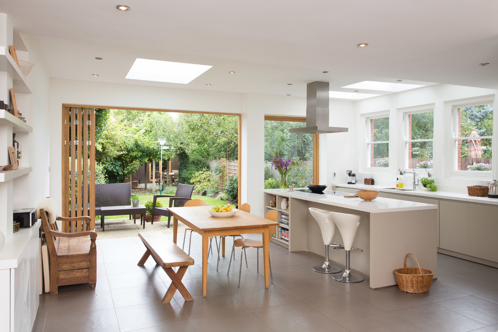 This is an example of a mid-sized contemporary eat-in kitchen in Other with an undermount sink, flat-panel cabinets, grey cabinets, solid surface benchtops, ceramic floors and with island.