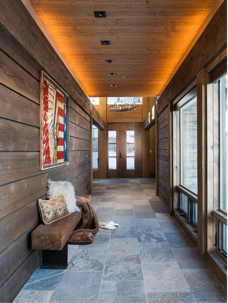 This is an example of a large country hallway in Other with brown walls, grey floor and slate floors.