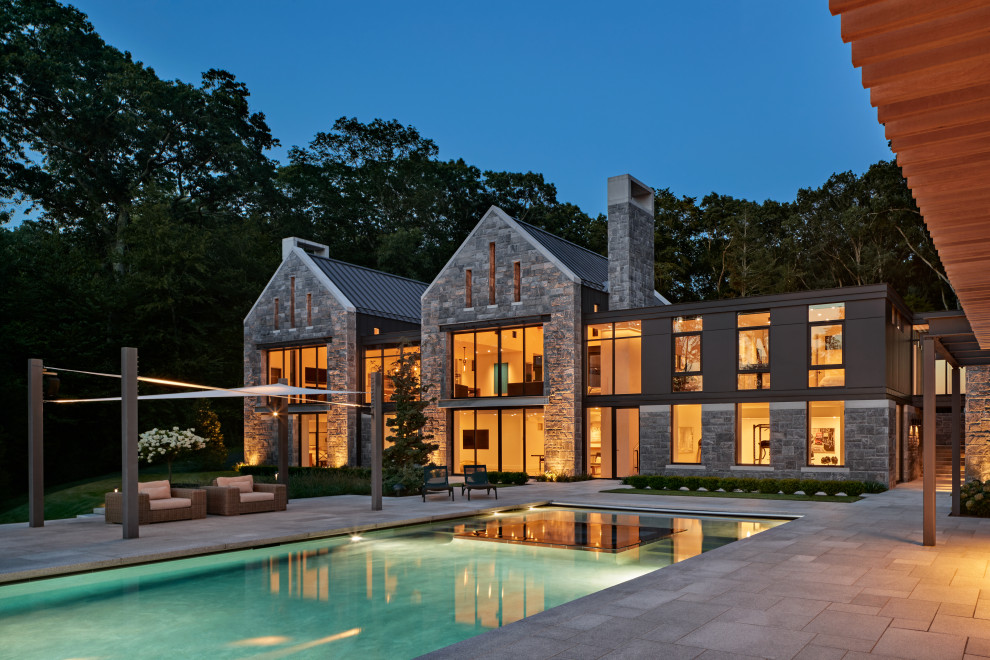 Large contemporary gray two-story stone house exterior idea in New York with a gray roof