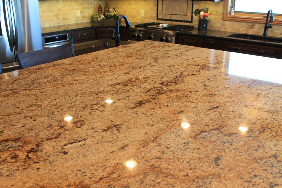 Mid-sized mountain style u-shaped medium tone wood floor kitchen photo with raised-panel cabinets, dark wood cabinets, granite countertops, beige backsplash, ceramic backsplash, black appliances and an island