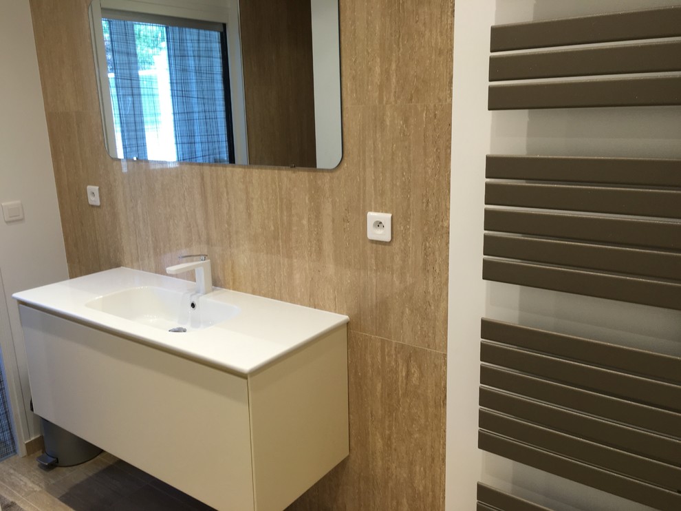 Expansive modern master bathroom in Paris with flat-panel cabinets, white cabinets, a curbless shower, a wall-mount toilet, beige tile, beige walls, a console sink, solid surface benchtops, stone tile and travertine floors.