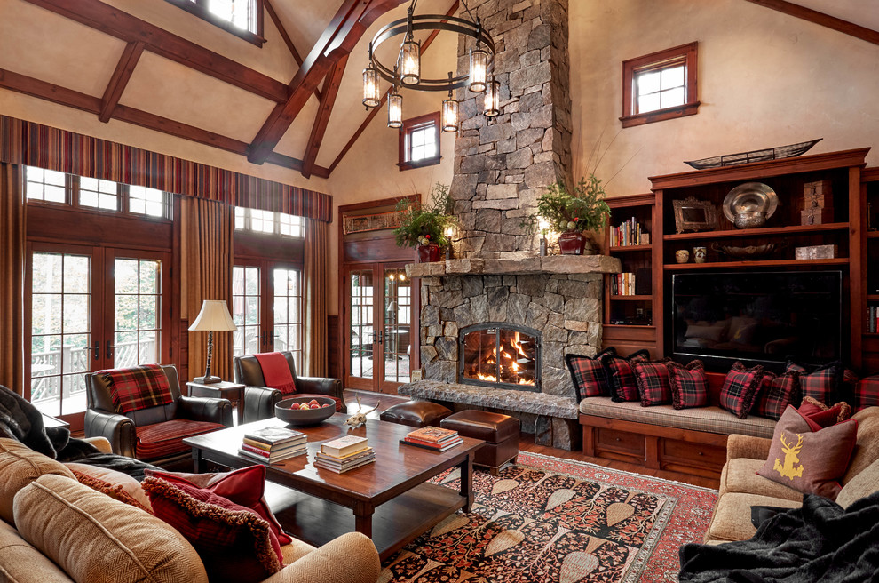 This is an example of a large country open concept living room in Burlington with beige walls, a standard fireplace, a stone fireplace surround, brown floor, medium hardwood floors and a built-in media wall.