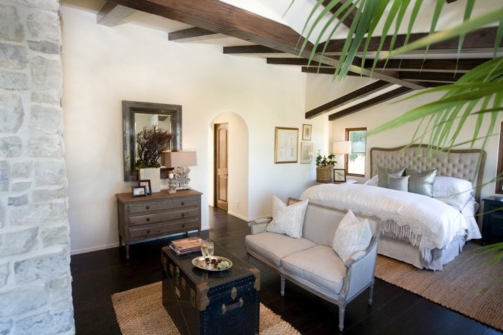 Design ideas for a mid-sized tropical master bedroom in Los Angeles with white walls, dark hardwood floors and brown floor.