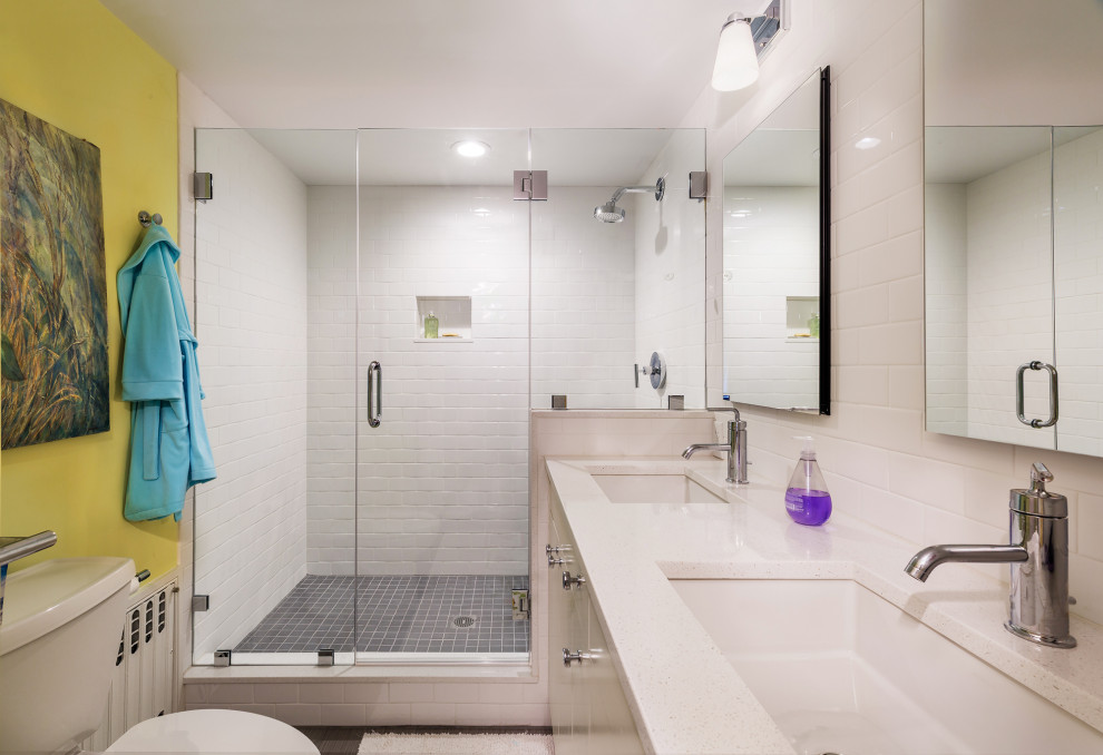 Exemple d'une salle de bain moderne de taille moyenne avec des portes de placard blanches, un carrelage blanc, des carreaux de céramique, un mur jaune, un sol en carrelage de céramique, un lavabo encastré, un plan de toilette en quartz modifié, un sol gris, une cabine de douche à porte battante, un plan de toilette blanc, meuble double vasque et meuble-lavabo encastré.