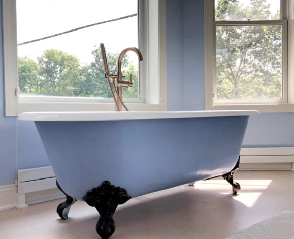 Inspiration for an expansive traditional master bathroom in St Louis with raised-panel cabinets, white cabinets, white tile, porcelain tile, solid surface benchtops, a claw-foot tub, a two-piece toilet, blue walls, laminate floors, a pedestal sink, brown floor, a hinged shower door and a corner shower.