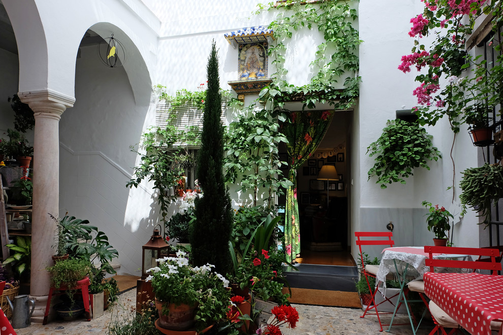 Large shabby-chic style courtyard patio in Other with natural stone pavers and no cover.