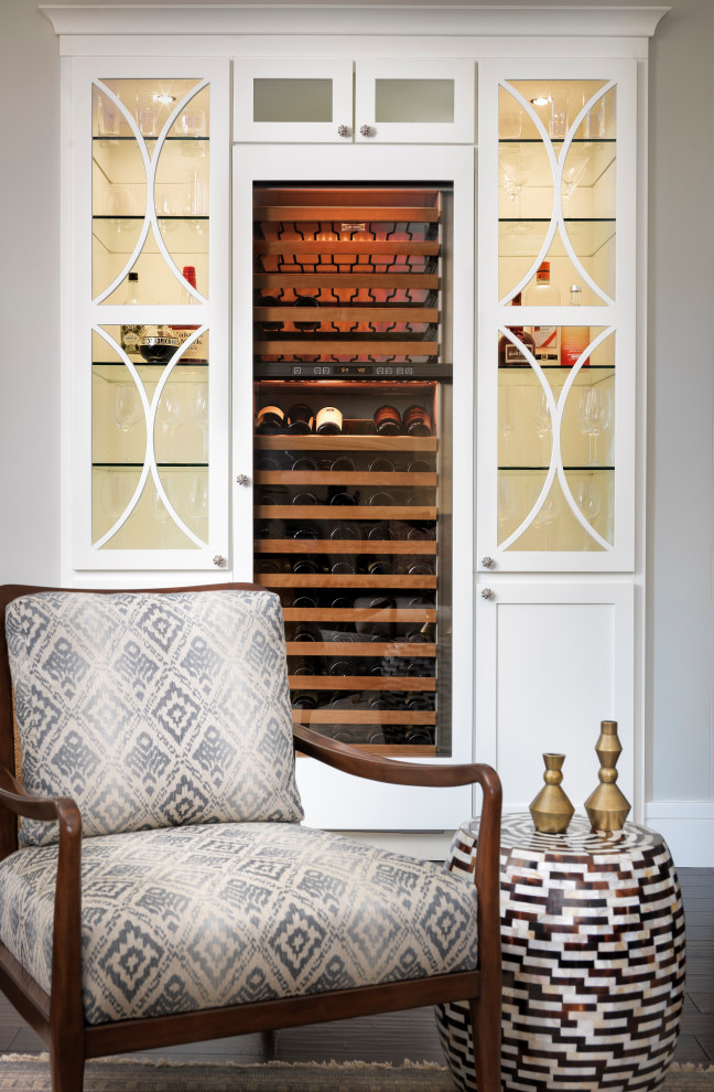 Transitional dark wood floor wine cellar photo in Denver with display racks