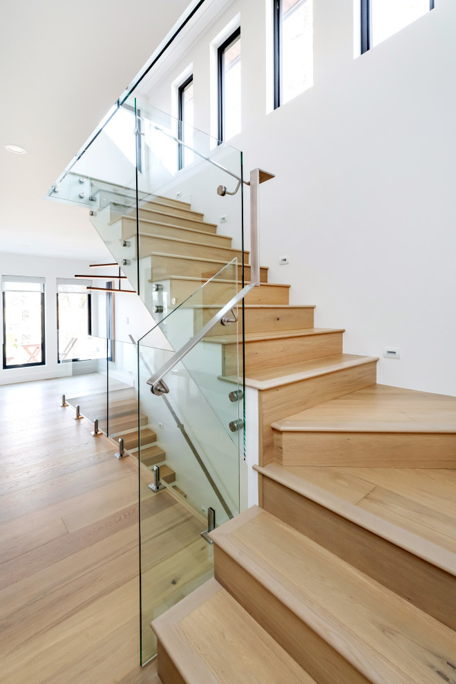 Example of a large minimalist light wood floor and beige floor staircase design with white walls
