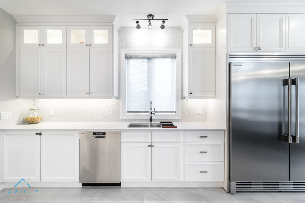 Example of a large transitional u-shaped porcelain tile enclosed kitchen design with recessed-panel cabinets, white cabinets, quartz countertops, white backsplash, marble backsplash, stainless steel appliances, an island and white countertops