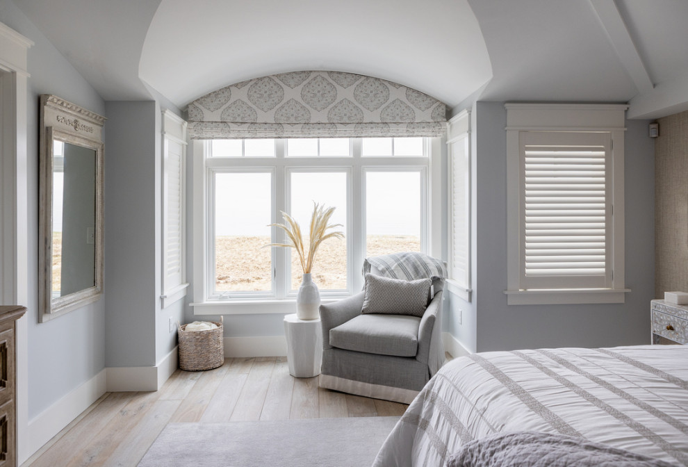 Inspiration for a large beach style master bedroom in Boston with blue walls, light hardwood floors, vaulted and wallpaper.