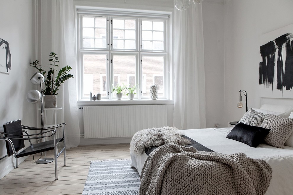 Design ideas for a large scandinavian bedroom in Malmo with white walls, light hardwood floors and beige floor.