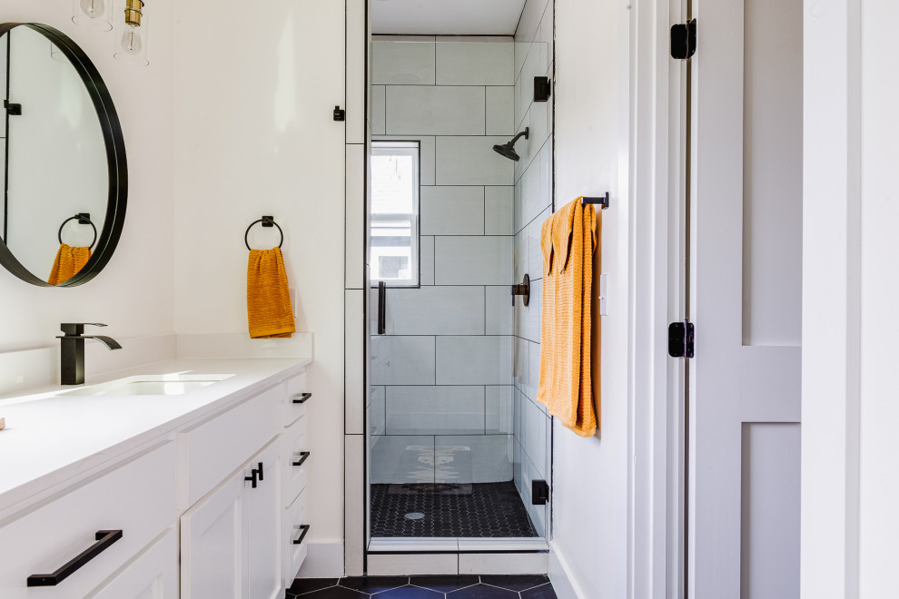 Пример оригинального дизайна: ванная комната в современном стиле с белой плиткой, белыми стенами, черным полом, душем с распашными дверями, белой столешницей и тумбой под две раковины