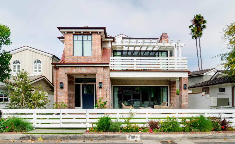 Large beach style two-storey brick red house exterior in Orange County.