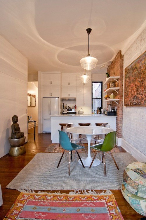 Design ideas for a small eclectic galley eat-in kitchen in New York with an undermount sink, shaker cabinets, white cabinets, marble benchtops, white splashback, subway tile splashback, white appliances, medium hardwood floors, with island and brown floor.