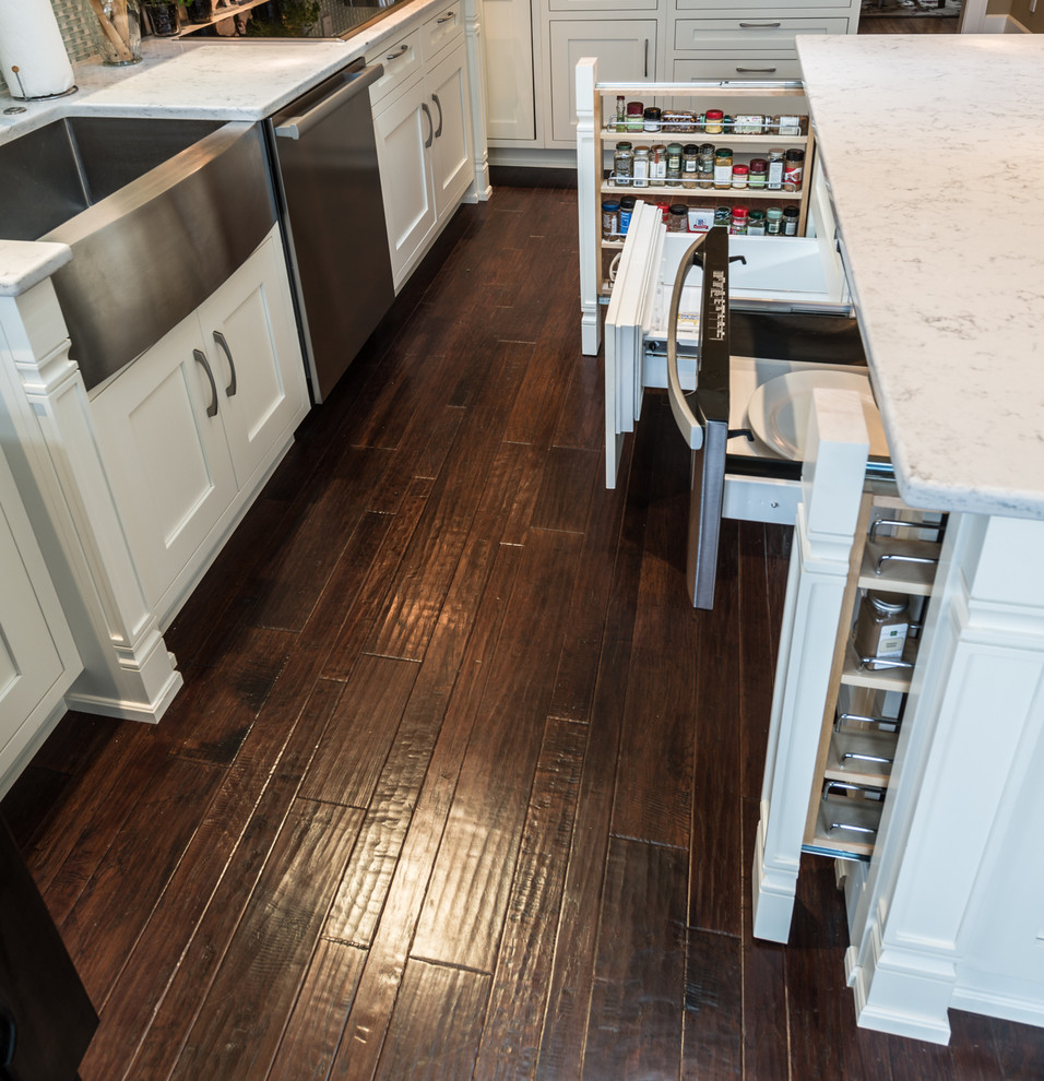 Inspiration for a large transitional l-shaped eat-in kitchen in Indianapolis with a farmhouse sink, shaker cabinets, white cabinets, quartz benchtops, blue splashback, mosaic tile splashback, stainless steel appliances, medium hardwood floors and a peninsula.
