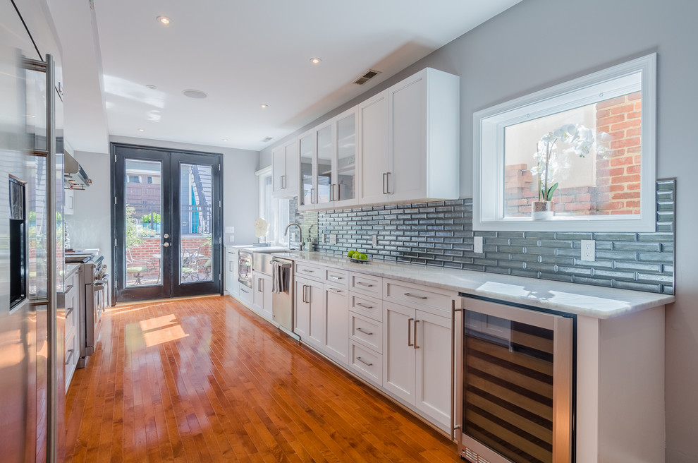 Large contemporary galley eat-in kitchen in Baltimore with an undermount sink, beaded inset cabinets, white cabinets, marble benchtops, blue splashback, glass tile splashback, stainless steel appliances, medium hardwood floors and no island.
