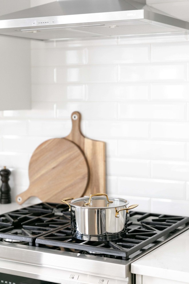 Eat-in kitchen - large transitional u-shaped medium tone wood floor and brown floor eat-in kitchen idea in Calgary with an undermount sink, shaker cabinets, white cabinets, quartzite countertops, white backsplash, subway tile backsplash, stainless steel appliances, an island and white countertops