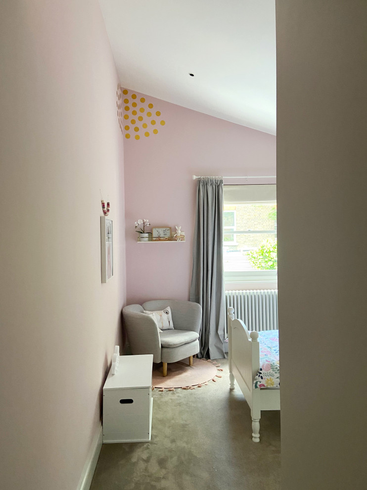 Foto di una cameretta per bambini da 4 a 10 anni con pareti rosa, moquette e pavimento beige