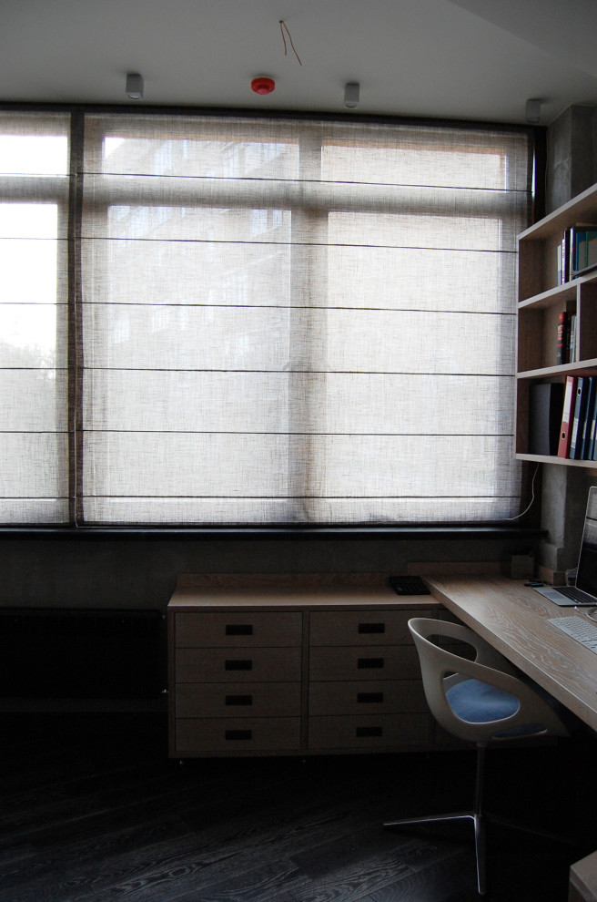 Eklektisk inredning av ett stort hemmabibliotek, med grå väggar, mörkt trägolv, ett inbyggt skrivbord och svart golv