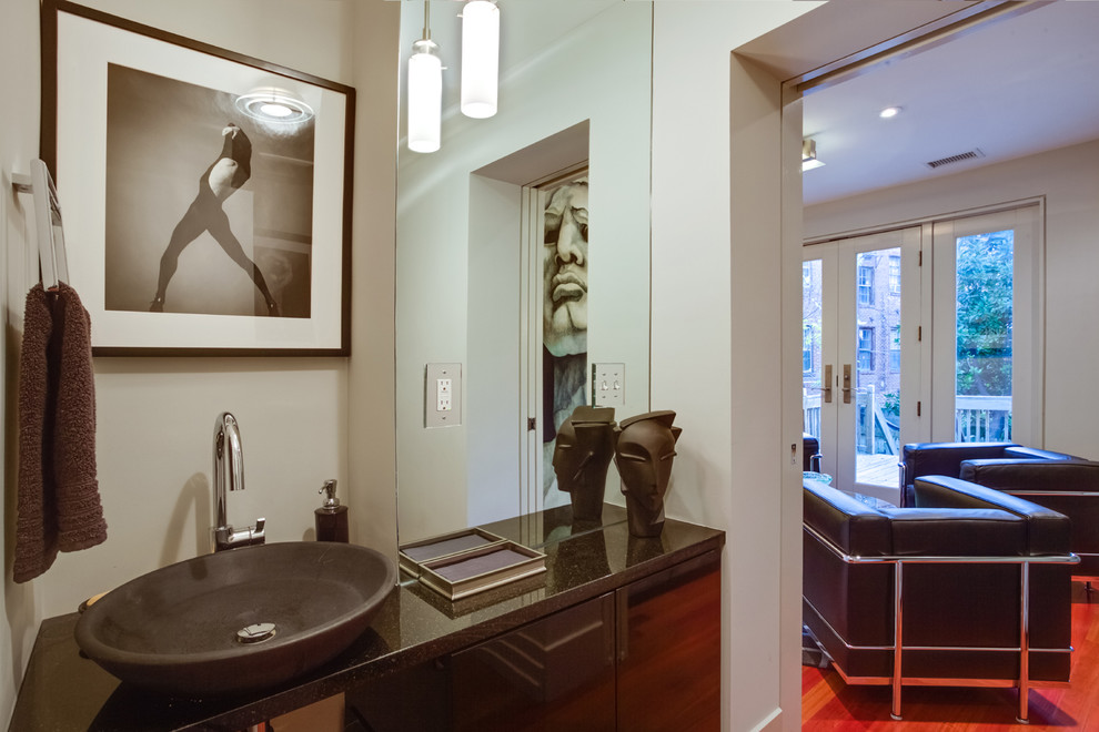 Photo of a small contemporary powder room in DC Metro with a vessel sink, flat-panel cabinets, black cabinets, granite benchtops, a two-piece toilet, grey walls and dark hardwood floors.