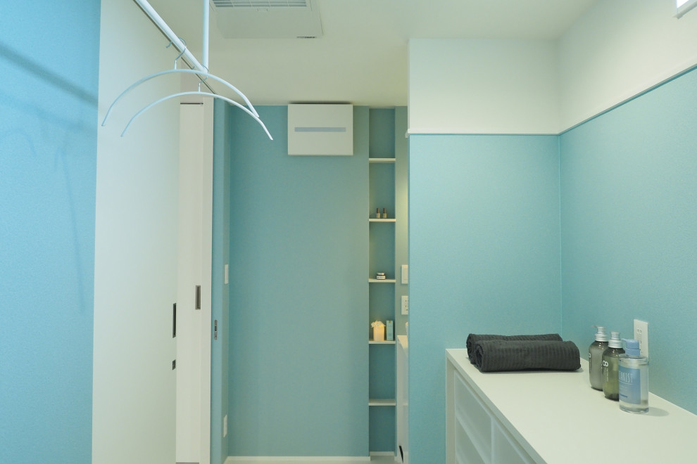 Idée de décoration pour un WC et toilettes design avec un mur bleu, un sol blanc et un plafond en papier peint.