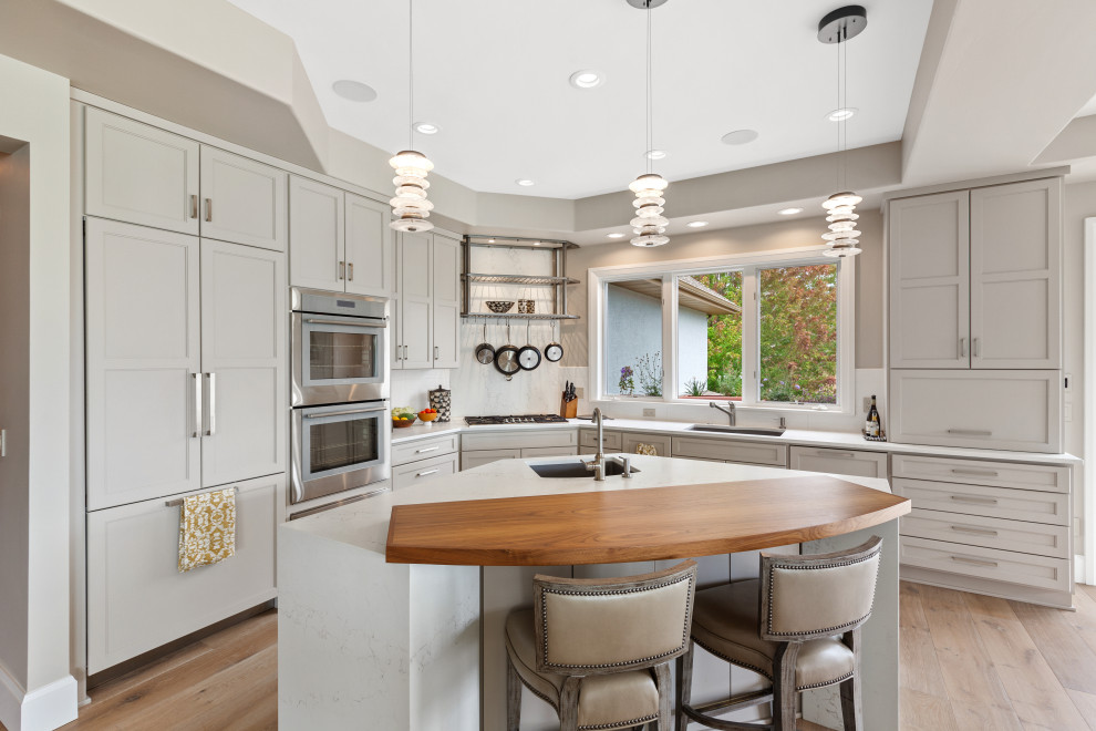 Photo of a mid-sized contemporary l-shaped separate kitchen in Seattle with a double-bowl sink, beaded inset cabinets, grey cabinets, quartz benchtops, white splashback, engineered quartz splashback, stainless steel appliances, light hardwood floors, with island, beige floor, white benchtop and coffered.