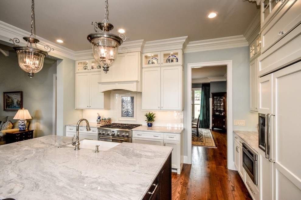 This is an example of a large country single-wall open plan kitchen in Charlotte with a farmhouse sink, shaker cabinets, white cabinets, granite benchtops, white splashback, subway tile splashback, stainless steel appliances and with island.