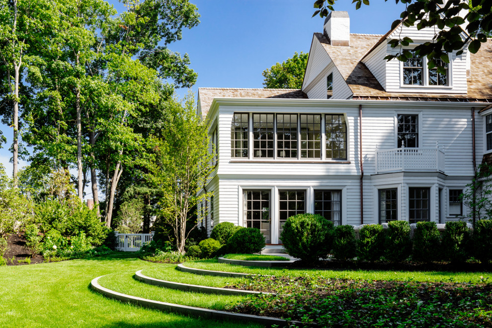 Large elegant white three-story wood and clapboard exterior home photo in Boston with a shingle roof and a brown roof
