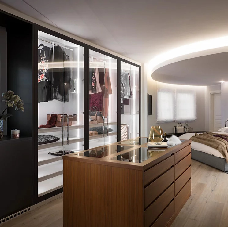 Design ideas for a mid-sized modern gender-neutral walk-in wardrobe in New York with beaded inset cabinets, white cabinets, light hardwood floors, white floor and wood.