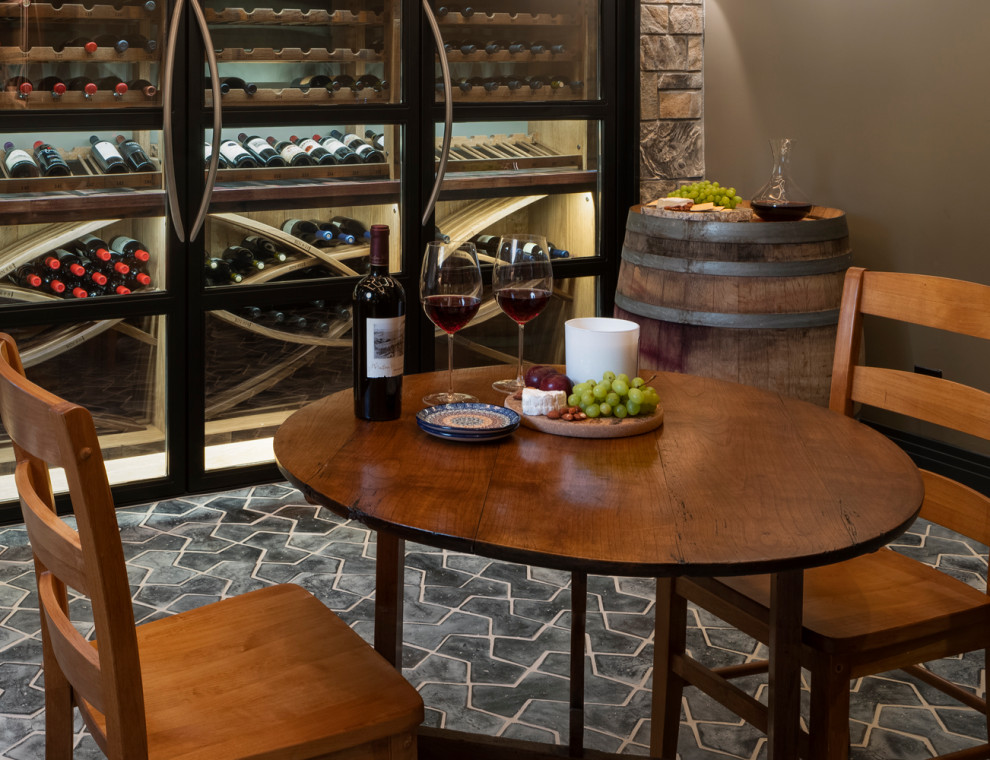 Photo of a large arts and crafts wine cellar in Denver with terra-cotta floors, display racks and black floor.