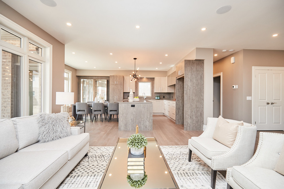 Example of a large transitional l-shaped medium tone wood floor and gray floor eat-in kitchen design with an undermount sink, flat-panel cabinets, gray cabinets, quartzite countertops, gray backsplash, stainless steel appliances, an island and gray countertops