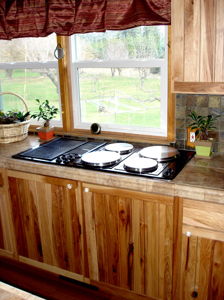 Inspiration for a mid-sized rustic u-shaped bamboo floor eat-in kitchen remodel in Seattle with an undermount sink, tile countertops, stone tile backsplash, stainless steel appliances and an island