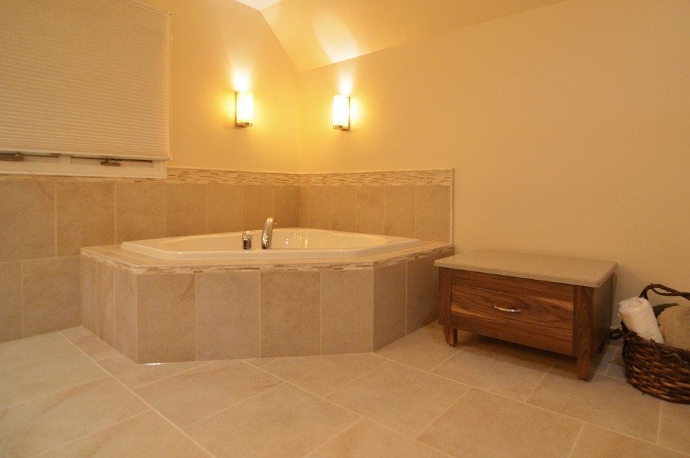 This is an example of a traditional bathroom in Chicago with an undermount sink, shaker cabinets, medium wood cabinets, engineered quartz benchtops, a drop-in tub, a corner shower, a two-piece toilet, beige tile and porcelain tile.