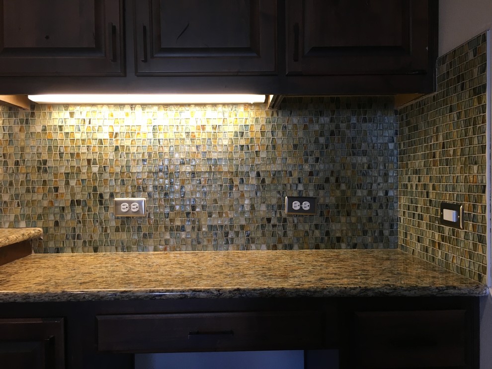 Example of a mid-sized transitional l-shaped eat-in kitchen design in Austin with an undermount sink, recessed-panel cabinets, dark wood cabinets, granite countertops, multicolored backsplash, glass sheet backsplash, stainless steel appliances and an island